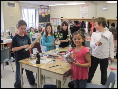 Male and female students in a classroom making crafts